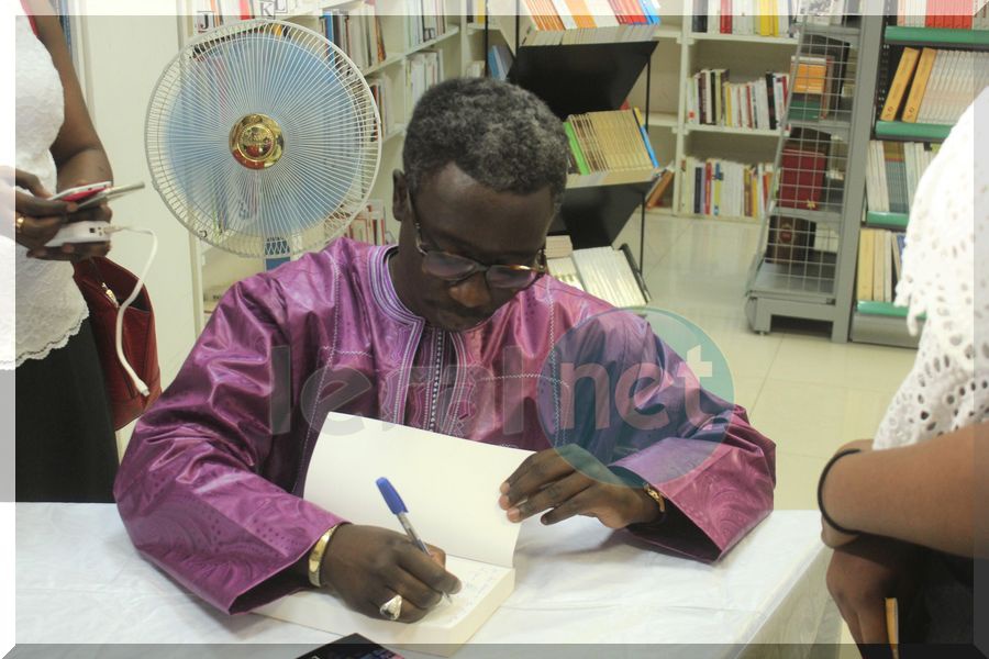 Photo Pape Ngagne Ndiaye en train de dédicacer son ouvrage